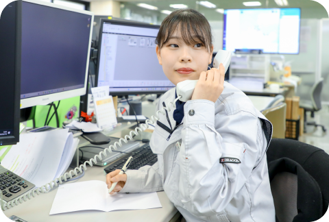 お客様からの電話をとる事務スタッフ